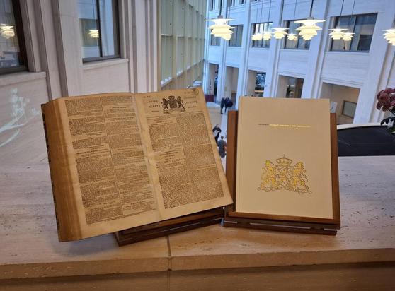Foto met Staatscourantboek (links) uit 1825 en de grondwet (rechts)