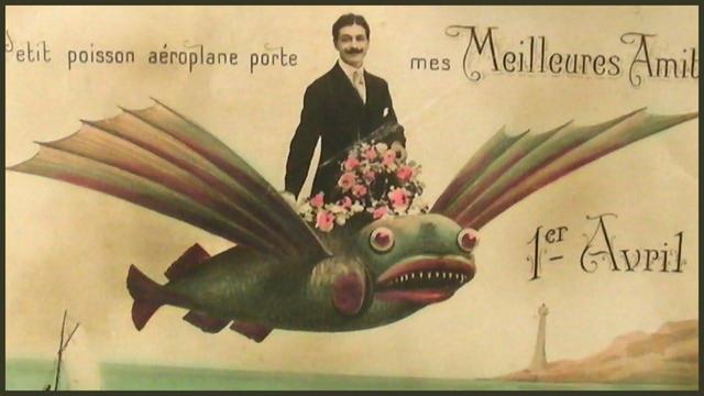 1 April Fish vintage postcard with a moustache-wearing old timey gentleman in a black suit, riding a flying fish.
