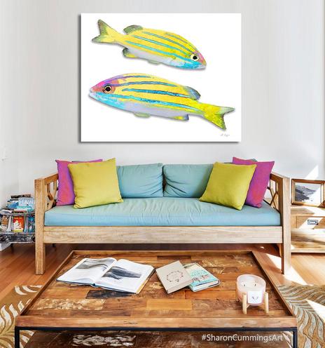 Two yellow and blue grunt fish above a tropical brightly colored sofa by artist Sharon Cummings.