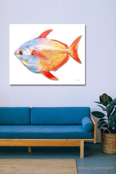 Orange and blue moonfish on crisp white painted in a unique style above a blue sofa by artist Sharon Cummings.