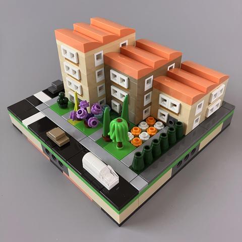The four storey block has a 3- and 2-storey block next to it, staggered backwards away from the road, arranged in descending height order