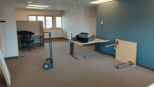 A photo of the new aftersight office pre move. Messy but also bare. random desks and ceiling tiles abound. 