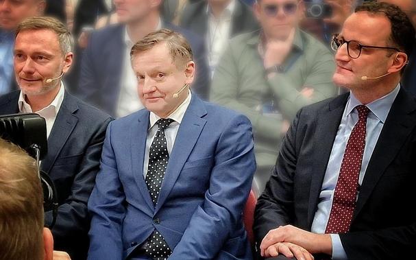 Auf einer IHK-Veranstaltung: Afd-Gottschalk, FDP-Lindner, CDU-Spahn sitzen zusammen. Gottschalk grinst erfreut in die Kamera.​