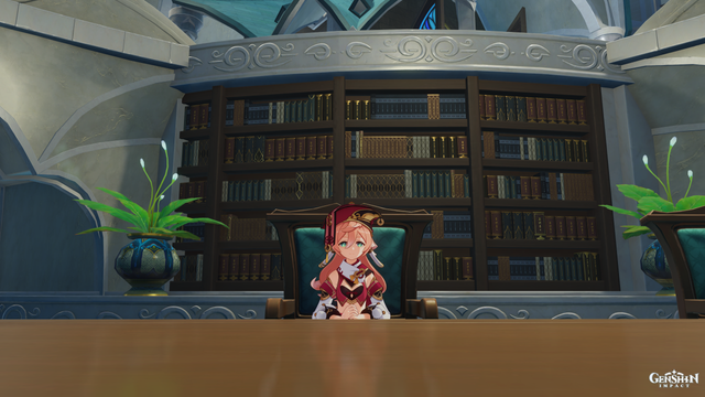 Yanfai sitzt am Tisch. Hinter ihr ein Regal mit Büchern. Neben dem Buchregal sind links und rechts jeweils eine Pflanze