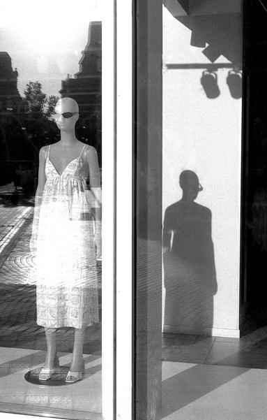 Un mannequin et son ombre dans une vitrine.