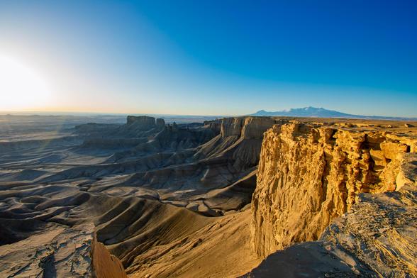 Sunrise at Moonscape Overlook, Utah. View from the top of a canyon rim.  Clear blue sky.