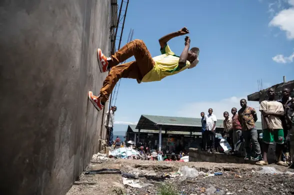 A breakdancer bounces off a wall.