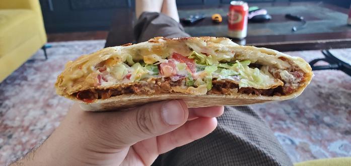 Me holding half of a wrap showing the layers of warm toasted yummyiness