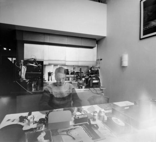 Black and white self portrait taken with a pinhole camera at home. A bit of a mess on my kitchen table.