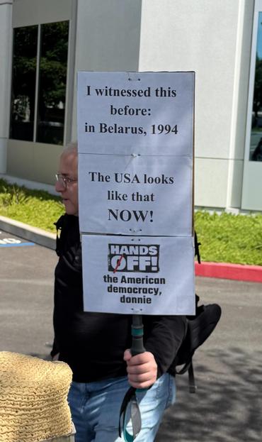 A man with a sign saying “I witnessed this before: In Belarus, 1994.  The U.S. looks like that now!”