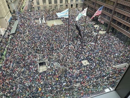 Daley Plaza in Chicago, seen from above, completely swarmed with people marching in opposition to Trump, Musk, Project 2025, and against other right wing nonsense.
