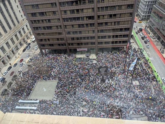 Daley Plaza in Chicago, seen from above, completely swarmed with people joining in opposition to Trump, Musk, Project 2025, and against other right wing nonsense.