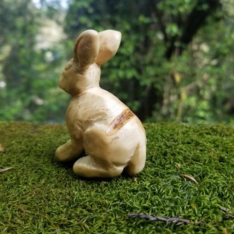 carved jackrabbit facing away and to the left, showing a horizontal heartwood scar across its back
