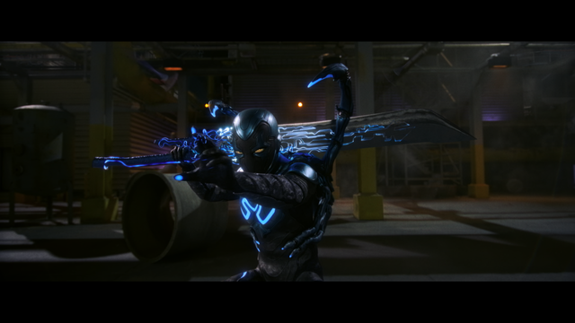 Screenshot from the movie Blue Beetle (2023) showing the Blue Beetle in pose with a large sword.