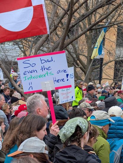 Photo d'une manif aux usa le 5 avril. Un monsieur tient une pancarte avec le message "ça va tellement mal, que même les introvertis sont là ! "