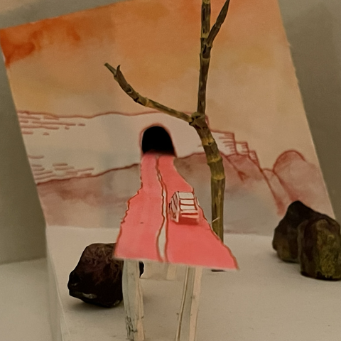 The pink road is engulfing itself in a tunnel on a wall