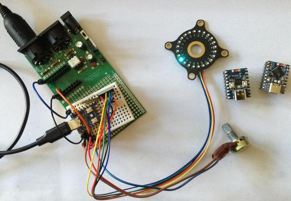 Photo of a mini solderless breadboard with a Waveshare Zero format RP2040 board connected to a potentiometer and an I2C LED ring.  It is also connected to the MIDI interface part of a previous PCB of mine.