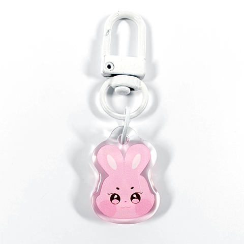 A picture of an acrylic keychain of Seonghwa's Aniteez animal from the K-Pop group ATEEZ. It's the head of the pink rabbit smiling like his original design. The rim of the keychain is clear. It has a white clasp.