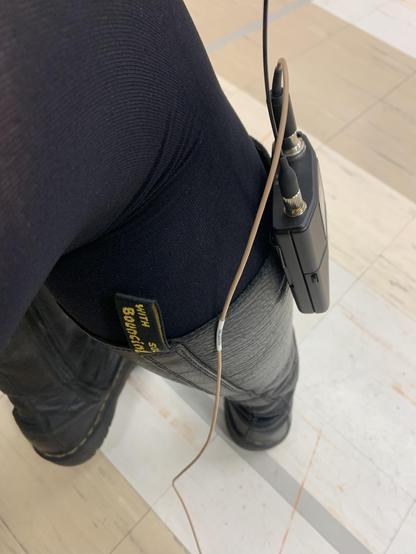 A mic pack clipped on to the top of knee high Doc Martin boots