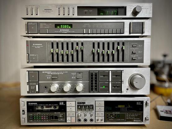 A stack of stereo components, silver colored with grey accents. 