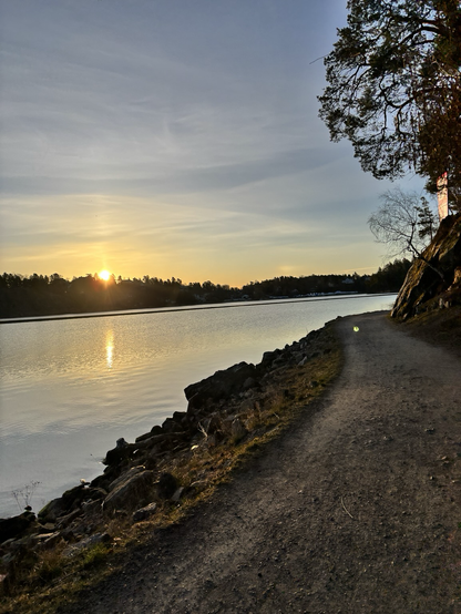 Sunrise over water next to a walking path