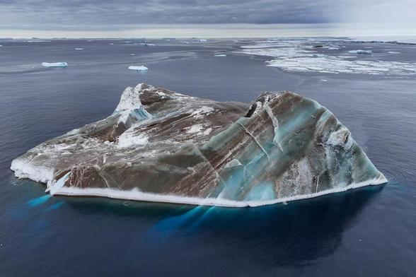 A brown iceberg with jade-like layers.
