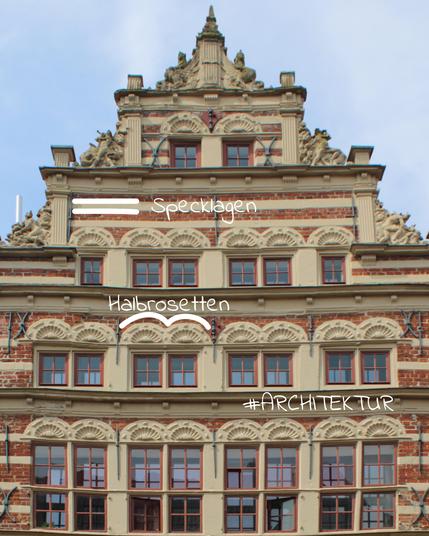Ein reich verziertes Haus: Ziegelsteinen und hellem Sandstein. Die Fenster weisen Sprossen auf, darüber befinden sich Halbrosetten. Die Fassade ist durchzogen von Streifen aus Standstein (sogenannte Specklagen). Der Giebel ist reich verziert.