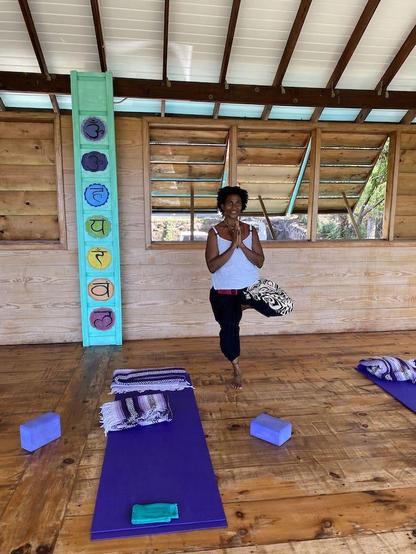 Yoga Instructor Marcia Cameron at True Blue Bay foing a balancing pose and holding her hands in gratitude.