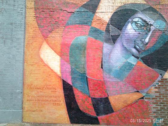 Large mural on a brick wall featuring a stylized woman's portrait, abstract shapes, and text including a quote by T.S. Eliot.