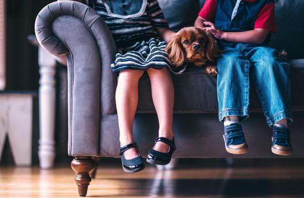 Kinder mit Hund auf Couch