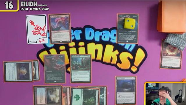 Eilidh's playmat on Elder Dragon Hijinks with Magic cards and an InfiniTokens dry erase token. On the InfiniToken Eilidh has drawn a dragon flying while breathing fire up into the air. 