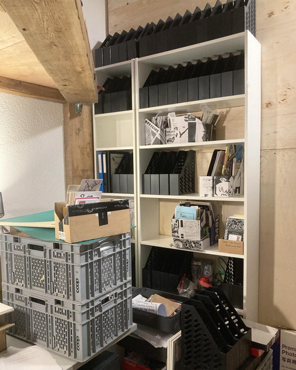 Bibliothèque avec boites pour revues partiellement vide.