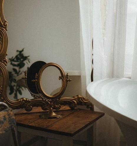A bathroom featuring a large mirror above a stylish bathtub, with neutral-colored walls and modern fixtures