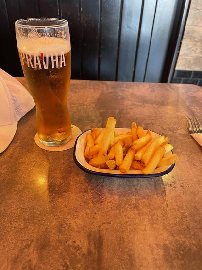 A pint of Pravda lager and a bowl of French fries 