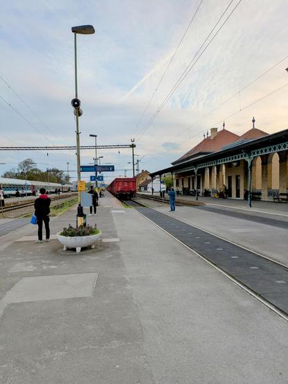 Sicht vom Bahnsteig 2 im Bahnhof Szeged auf einen Güterzug und einen Intercity.