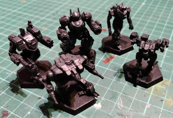 Five BattleTech minis painted blue-tinted dark grey, placed on a green cutting mat.

The middle-center one, a Crossbow, got painted wrong instead of a Nova.