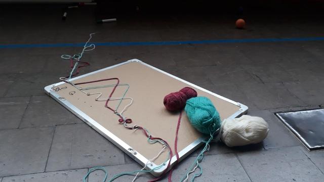 Souvenir du dernier stage jonglage à Chenôve : un tableau en liège avec, dessus, du fil à tricoter punaisé en forme de diagramme de Siteswaps, théorie du jonglage.