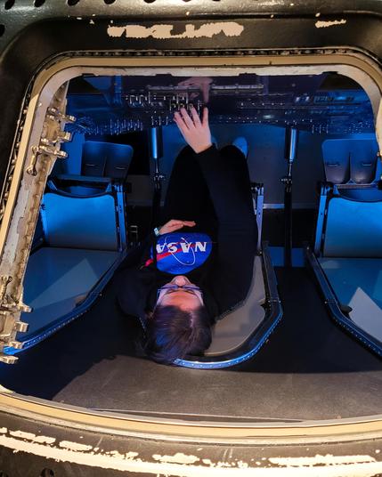 Me wearing a nasa sweatshirt inside the Apollo spacecraft simulator