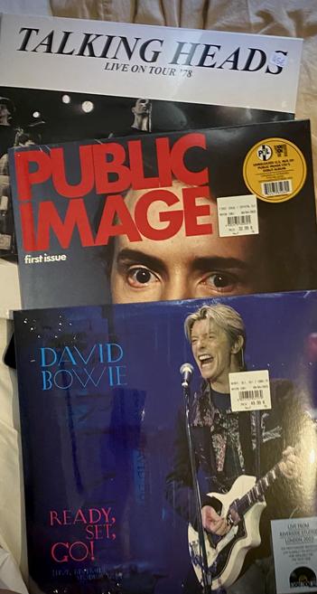 The image features three vinyl records stacked together. The top record is titled "Talking Heads: Live on Tour '78." Below it is "Public Image," the first issue featuring a close-up of a person's eyes. The bottom record is "David Bowie Ready, Set, Go! Live 2003”. 
