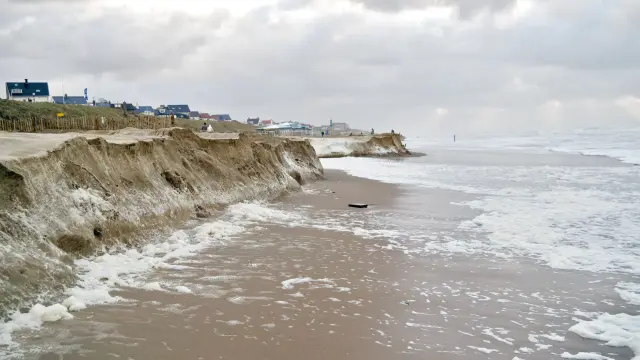Photo of sandy coast being deeply eroded. Posted without credit with Commonwealth Beacon story.