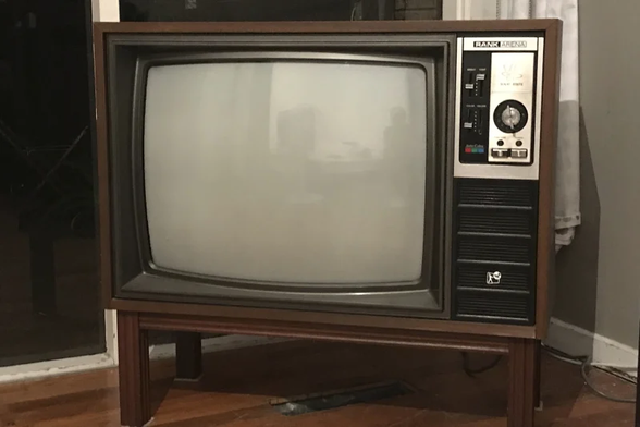 Image of a 1980s woodgrain TV. Approximately 20 or 25 inches, and has analog dials on the front. 
