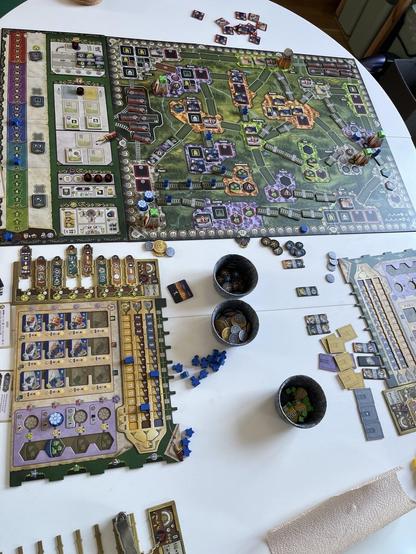 A white table with colourful boardgame elements spread out and the board depicting a stylised rail map of leipzig and neighbouring towns