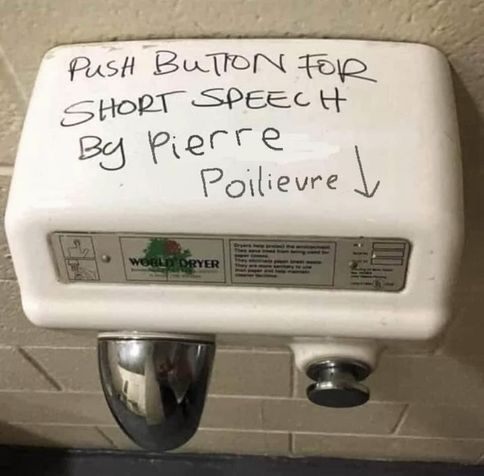 Public washroom mechanical hand drier with graffiti "Push button for a short speech by Pierre Poilievre"