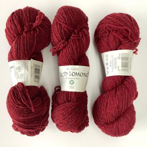 Three deep-red skeins of yarn on a white background.
