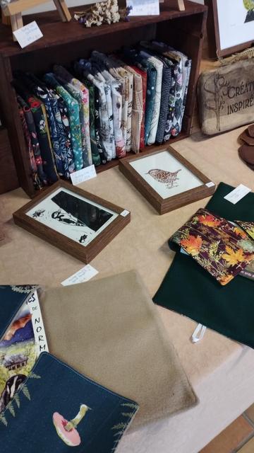 Photo de mon stand avec des protèges livres exposés ainsi que des linogravures