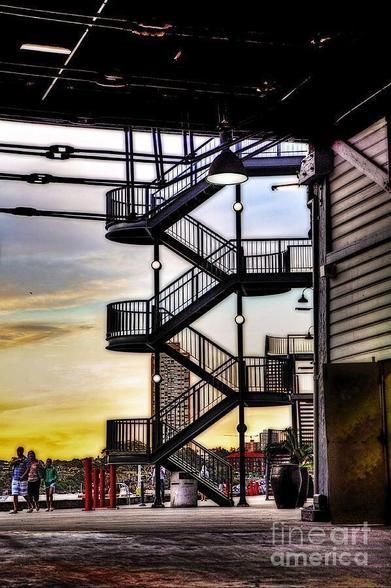 Whilst spending a day viewing the activities and festivities for the Australian Navy Centenary in October, 2013, strolling back through 'The Rocks' area of Sydney (Circular Quay), I noticed an old staircase through a walkway between one of the old docks on Sydney Harbor. It was a lovely view with the sun setting behind, creating a partial silhouette. This area has so much character and charm; I could spend days just walking around admiring its old architecture and beauty.  By Kaye Menner Photography.

THE FINE ART AMERICA LOGO WILL NOT APPEAR ON PURCHASED PRINTS OR PRODUCTS.