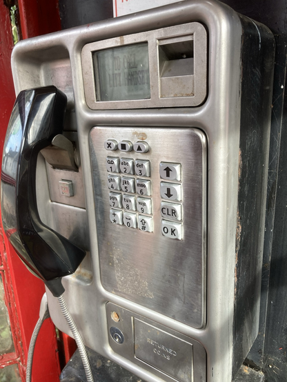 Push button coin operated phone in red British phone box