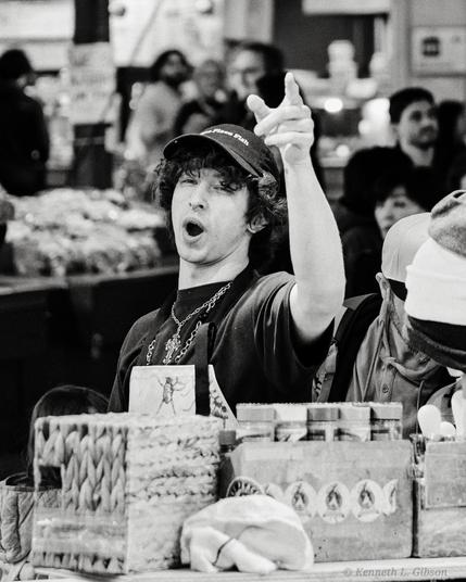 Black and white image of fish monger at Pike Place Fish Market.  Known for throwing fish back and forth.