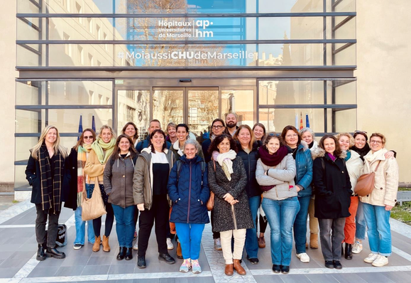 Photo de groupe devant la Direction Générale de l’AP-HM à Marseille, réunissant une vingtaine d’IPA souriants, à l’occasion de la création officielle de leur collégiale le 17 janvier 2025.