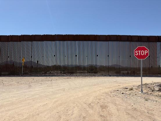 Title: Trump Makes It Harder To Self-Deport

Alt Text: Photograph of a tall fence at the US-Mexico border. In the foreground is a stop sign. the photograph is taken from the middle of the road.

Photographer: Marshall Mayer aka @AuthenticPhoto

Date and Time: March 25, 2023 at 11:56 am

Location: South Puerto Blanco Drive (US2) near Lukeville, Arizona USA

License: CC BY-NC-ND 4.0

Caption: This fence is the border between the United States and Mexico. It was built by Donald Trump in his first administration. It did not make much difference. Now it makes it difficult for anyone to self-deport, in itself a ridiculous policy. But that's par for the course when it comes to a demented bully.

Hashtags: #Trump #southernborder #immigration #self-deport #stop #ICE #authentic #photography 

Source: https://take-note.com/note-takers/marshall--mayer/notes/trump-makes-it-harder-to-self-deport.jpeg/view